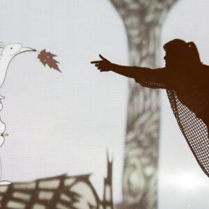 Abigail Baird performing aerial acrobatics in front of projected animation