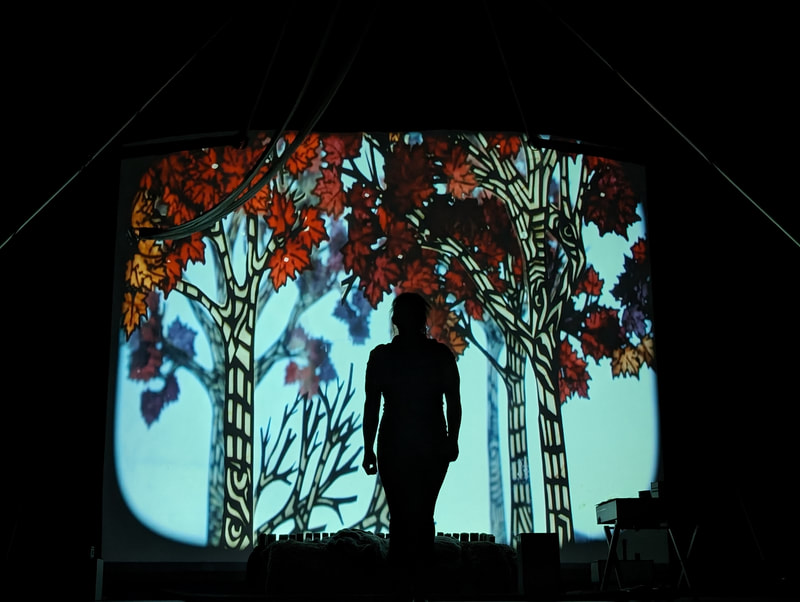 Backlit cut-paper autumn forest scene