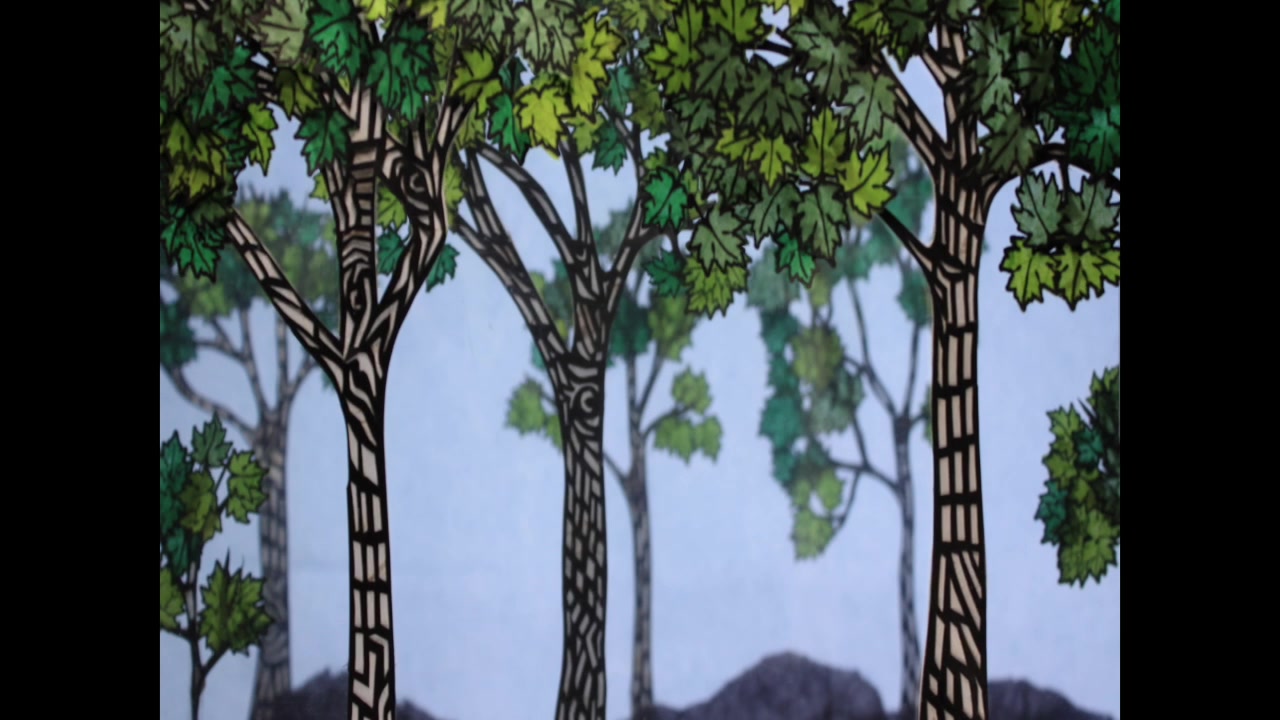 Detail of Abigail Baird hand-cut paper forest art with patterned trunks and layered leaves