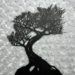 An intricate hand-cut paper tree silhouette by Abigail Baird