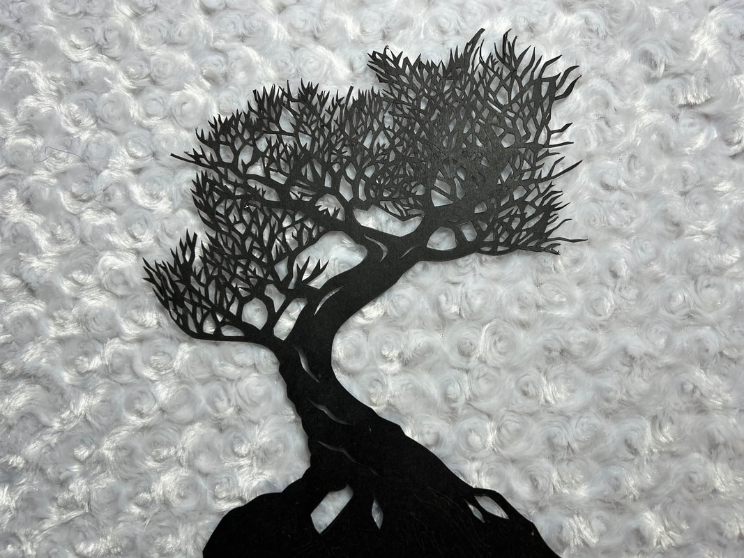 An intricate hand-cut paper tree silhouette